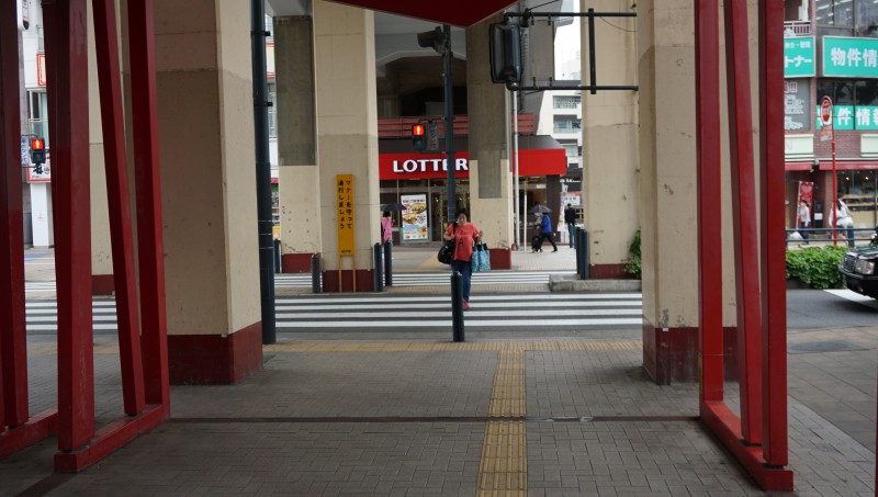 ① 改札口を出て信号を渡る